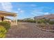 Spacious backyard with a covered patio, desert landscaping, and stunning views at 10421 Linfield Pl, Las Vegas, NV 89134