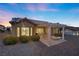 Backyard at dusk with covered patio, desert landscaping, and exterior lighting at 10421 Linfield Pl, Las Vegas, NV 89134