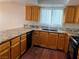 Galley kitchen with wood cabinets, granite countertops, and dark appliances at 9421 Amber Valley Ln, Las Vegas, NV 89134