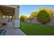 Landscaped backyard with artificial turf, covered patio, and block wall at 6258 Windfresh Dr, Las Vegas, NV 89148