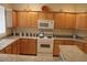 Modern kitchen with light wood cabinets, granite countertops, and white appliances at 8788 Seal Rock Ct, Las Vegas, NV 89147