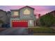 Two-story house with red garage door and landscaped front yard at 1808 Cedar Bluffs Way, Las Vegas, NV 89128