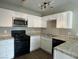 Modern kitchen with white cabinets and black appliances at 4017 Foxgrove Dr, Las Vegas, NV 89147