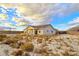 Large backyard with a view of the house and surrounding desert landscape at 5471 Lincolnwood Ct, Pahrump, NV 89061