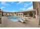 Large rectangular pool with surrounding lounge chairs and patio at 647 Foxhall Rd, Henderson, NV 89002