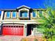 Two-story house with a red garage door and landscaping at 664 Stone Hammer Ave, Las Vegas, NV 89183