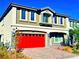 Two-story house with a red garage door and stone accents at 664 Stone Hammer Ave, Las Vegas, NV 89183