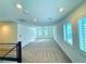 Spacious loft area with neutral carpeting and a ceiling fan at 664 Stone Hammer Ave, Las Vegas, NV 89183