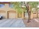 Townhouse exterior with two-car garage and landscaping at 693 Harbor Mist Ave, Henderson, NV 89015