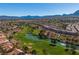 Aerial view of a golf course with water features and homes, set against a mountain range at 10301 Long Leaf Pl, Las Vegas, NV 89134