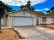 Front view of a single-story house with a white garage door at 6939 Paddington Way, Las Vegas, NV 89147