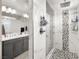 Bathroom with marble shower, double vanity, and gray cabinets at 70 Pikiariki Ct, Las Vegas, NV 89183