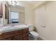 Clean bathroom with wood cabinets, a toilet, and a sink at 7720 W Agate Ave, Las Vegas, NV 89113