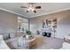 Living room with ceiling fan, neutral decor, and ample natural light at 8233 San Mateo St, North Las Vegas, NV 89085