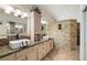 Bathroom with dual sinks, stone wall accents, and a large shower at 5200 Wheatland Dr, Pahrump, NV 89061