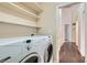 Functional laundry room with washer, dryer, and overhead shelving at 7232 Tealwood St, Las Vegas, NV 89131