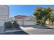 Two-car garage with a white exterior and landscaping at 7465 Desert Flame Ct, Las Vegas, NV 89149