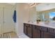 Double vanity bathroom with dark wood cabinets and a large mirror at 996 Via Stellato St, Henderson, NV 89011