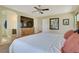 Bright bedroom with king-size bed, en-suite bathroom access, and large TV at 996 Via Stellato St, Henderson, NV 89011