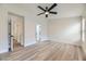 Spacious bedroom featuring wood-look floors, ceiling fan, and access to hallway and bathroom at 10810 Porto Foxi St, Las Vegas, NV 89141