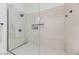 Walk-in shower with neutral tile, built-in shelves, and glass enclosure at 10810 Porto Foxi St, Las Vegas, NV 89141