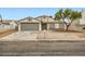 Beige house with gray garage door and landscaped yard at 1269 Jarbridge Rd, Las Vegas, NV 89110