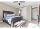 Spacious bedroom with a comfortable bed, bench, and ample closet space at 3377 Royal Fortune Dr, Las Vegas, NV 89141