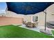 Backyard patio with seating, umbrella, and artificial turf at 5266 Sherwood Forest Ln, Las Vegas, NV 89122