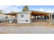 Single-wide manufactured home with covered parking and fenced yard at 61 W Wilderness Way, Pahrump, NV 89048