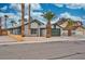 Single-story house with a green garage door and mature palm trees at 7230 Mountain Moss Dr, Las Vegas, NV 89147