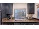 Close-up of the kitchen sink area with granite countertops, dark cabinets, and a window at 4889 S Torrey Pines Dr # 105, Las Vegas, NV 89103