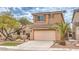 Beige two-story house with attached garage and desert landscaping at 5327 Caprock Canyon Ave, Las Vegas, NV 89139