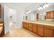 Bathroom with double vanity, wood cabinets and access to bedroom at 7119 Wolf Rivers Ave, Las Vegas, NV 89131