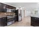 Modern kitchen with dark wood cabinets, granite counters and stainless steel appliances at 5220 Jose Ernesto St, North Las Vegas, NV 89031