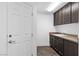 Laundry room with dark cabinets and tile floor at 5678 Robin Ridge Ave, Las Vegas, NV 89141