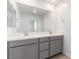 Double vanity bathroom with gray cabinets and mirrors at 6176 Foxes Dale St, Las Vegas, NV 89166