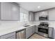 Modern kitchen with gray cabinets, white countertops, and stainless steel appliances at 6176 Foxes Dale St, Las Vegas, NV 89166