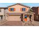 Two-story house with orange accents and a brick driveway at 1648 Desert Path Ave, North Las Vegas, NV 89032