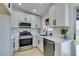 Modern kitchen with white cabinets, stainless steel appliances, and quartz countertops at 459 Ash St, Henderson, NV 89015