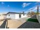 Exterior view of the home's back, showcasing a white exterior and a landscaped backyard at 5821 Harmony Ave, Las Vegas, NV 89107