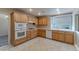 Kitchen with wood cabinets, gas cooktop and white appliances at 2277 Black Pine Dr, Las Vegas, NV 89134