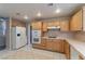 Kitchen with wood cabinets, gas cooktop and white appliances at 2277 Black Pine Dr, Las Vegas, NV 89134