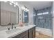 Modern bathroom with double vanity, blue tile, and a bathtub at 4623 Harvest Night St, Las Vegas, NV 89129