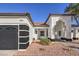 Single-story home with a red door, black garage door, and a nicely landscaped front yard at 5604 Island Breeze Ct, Las Vegas, NV 89130