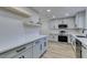 Modern kitchen with white shaker cabinets, quartz countertops and wood shelving at 647 Greenbriar Townhouse Way, Las Vegas, NV 89121