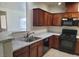 Modern kitchen with dark wood cabinets and a double sink at 8324 W Charleston Blvd # 2033, Las Vegas, NV 89117