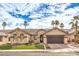 Single-story house with a two-car garage, landscaped yard, and palm trees at 268 Fair Play St, Henderson, NV 89052