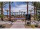 Circular playground with climbing structures, surrounded by palm trees and a basketball court at 445 Venticello Dr, Las Vegas, NV 89138