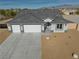 Aerial view of a house with a three-car garage and desert landscaping at 4900 Ridgewood Dr, Pahrump, NV 89061