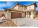 Two-story house with a brown door and attached garage at 5861 Lakeland Village Dr, North Las Vegas, NV 89081